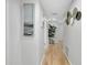 Bright hallway with light hardwood flooring, modern decor, and a view towards the living area at 6415 Midnight Pass Rd # 909, Sarasota, FL 34242