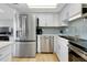 Well-lit kitchen with stainless steel refrigerator and appliances, plus attractive tile backsplash at 6415 Midnight Pass Rd # 909, Sarasota, FL 34242
