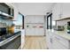 Modern kitchen with stainless steel appliances, white cabinets, and bright window view at 6415 Midnight Pass Rd # 909, Sarasota, FL 34242