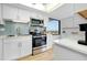 Bright kitchen with stainless steel appliances, white cabinets, and a window view at 6415 Midnight Pass Rd # 909, Sarasota, FL 34242