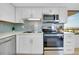 Well-lit kitchen features white cabinets, stainless steel appliances, and subway tile at 6415 Midnight Pass Rd # 909, Sarasota, FL 34242