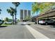 Spacious parking lot with covered parking and views of the building behind at 6415 Midnight Pass Rd # 909, Sarasota, FL 34242