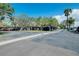 Spacious parking lot with covered parking spaces and mature trees at 6415 Midnight Pass Rd # 909, Sarasota, FL 34242