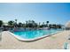 A large, well-maintained outdoor pool with lounge chairs and lush landscaping at 6415 Midnight Pass Rd # 909, Sarasota, FL 34242