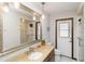 Bathroom featuring a large mirror, granite counter, and white tiled floors and walls at 6427 Canary St, Sarasota, FL 34241