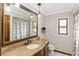 Bathroom featuring a decorative mirror, granite counters, cabinets, and a shower-tub combo at 6427 Canary St, Sarasota, FL 34241