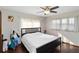 Bright bedroom with wood floors, white curtains, a black bed frame, and a ceiling fan at 6427 Canary St, Sarasota, FL 34241