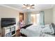 Bright bedroom with a ceiling fan, wood floors, and a window with light blue curtains at 6427 Canary St, Sarasota, FL 34241