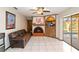 Inviting living room featuring a brick fireplace, ceiling fan, and sliding door access to the pool at 6427 Canary St, Sarasota, FL 34241