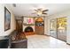 Inviting living room featuring a brick fireplace, ceiling fan, and sliding door access to the pool at 6427 Canary St, Sarasota, FL 34241