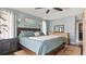 Comfortable bedroom features a ceiling fan, blue walls, and ensuite bathroom access at 648 Cypress Rd, Venice, FL 34293