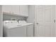 Laundry room with washer, dryer, and white cabinets at 648 Cypress Rd, Venice, FL 34293