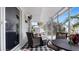 Relaxing screened-in porch with wicker furniture, ceiling fan, and tiled flooring at 648 Cypress Rd, Venice, FL 34293