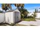 Backyard shed with gray doors, surrounding tropical landscaping and a brick pathway at 648 Cypress Rd, Venice, FL 34293