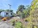 Lush backyard featuring a white garden shed, tropical plants, stone and mulch ground covering at 704 Serata St, Venice, FL 34285