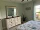 Charming bedroom with dresser, mirror and window offering plenty of natural light and comfort at 7427 Cape Girardeau St, Englewood, FL 34224