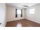 This bedroom features wood floors, ceiling fan, and curtains covering the windows at 781 Missouri Rd, Venice, FL 34293