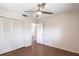 This bedroom features wood floors, ceiling fan, and a closet with folding doors at 781 Missouri Rd, Venice, FL 34293