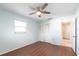 Charming bedroom features wood floors, a window, ceiling fan, and closet with bifold doors for storage at 781 Missouri Rd, Venice, FL 34293