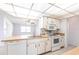 Functional kitchen featuring white appliances and an island with a sink overlooking the spacious living area at 781 Missouri Rd, Venice, FL 34293