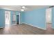 Bright bedroom with blue walls, wood-look floors, and ceiling fan at 891 Grado Dr, Venice, FL 34285