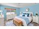 Bright bedroom featuring a white dresser, modern bed frame, and blue accents at 891 Grado Dr, Venice, FL 34285