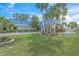 Lush landscaping frames the clubhouse entrance with a striking blue roof and well-manicured lawn at 891 Grado Dr, Venice, FL 34285