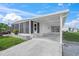 Bright exterior featuring a carport, screened porch, and well-maintained landscaping under a blue sky at 891 Grado Dr, Venice, FL 34285