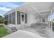 Angle view of the exterior featuring a carport, screened porch, and landscaped exterior at 891 Grado Dr, Venice, FL 34285