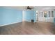 Bright living room with blue walls, light wood floors, and white built in storage cabinets at 891 Grado Dr, Venice, FL 34285