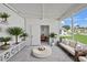 Covered patio with plenty of green vegetation, white walls, and string lights at 891 Grado Dr, Venice, FL 34285