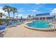 Community pool area with blue lounge chairs and tropical palm trees at 891 Grado Dr, Venice, FL 34285