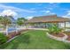 Outdoor recreation area with a thatched roof gazebo, lawn, and mature landscaping perfect for community gatherings and relaxation at 891 Grado Dr, Venice, FL 34285