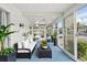 Bright sunroom with white furniture, stylish decor, and sliding glass doors leading to outdoors at 891 Grado Dr, Venice, FL 34285