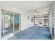 Enclosed sunroom with bright blue carpet, with many windows and access to outside at 891 Grado Dr, Venice, FL 34285