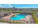 Aerial view of the community pool area featuring a uniquely shaped pool, lounge chairs, and covered pavilions at 8969 Mondial Ct, Venice, FL 34293