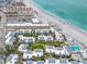 An overhead view of beachfront condos, showcasing the community pool and access to a pristine sandy beach at 902 Gibbs Rd # 181, Venice, FL 34285