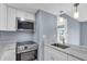 Modern kitchen with white cabinetry, stainless steel appliances, and marble countertops at 902 Gibbs Rd # 181, Venice, FL 34285