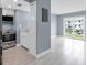 Modern kitchen features stainless steel appliances, light wood floors, and white cabinetry at 902 Gibbs Rd # 181, Venice, FL 34285