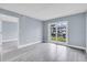 Living room with light walls, wood floors, and sliding doors to outdoor view at 902 Gibbs Rd # 181, Venice, FL 34285