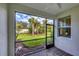 Enclosed lanai featuring brick flooring and serene views of the lush backyard and swaying palm trees at 9916 Bright Water Dr, Englewood, FL 34223