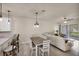 Open concept living and dining area with a modern lighting fixture and a sliding door to the outdoors at 9916 Bright Water Dr, Englewood, FL 34223