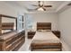Comfortable main bedroom featuring a bed, dresser, nightstands, tray ceiling, and shuttered windows at 9916 Bright Water Dr, Englewood, FL 34223