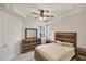 Comfortable main bedroom featuring a bed, dresser, nightstands, tray ceiling, and shuttered windows at 9916 Bright Water Dr, Englewood, FL 34223