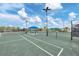 Well-maintained tennis court with blue canopies and ample seating area at 9916 Bright Water Dr, Englewood, FL 34223