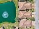 Aerial view of community homes with brown roofs next to a pond with fountain, and the road at 1018 Yosemite Dr, Englewood, FL 34223