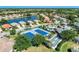 Community aerial view of lush landscaping, ponds with fountains, tennis courts, swimming pool, and neighborhood homes at 1018 Yosemite Dr, Englewood, FL 34223