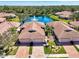 Stunning aerial view of a villa community with red tile roofs surrounding a tranquil lake and fountain at 1018 Yosemite Dr, Englewood, FL 34223