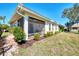 Lovely backyard with a screened-in lanai, brick paver border and a vibrant flower bush in full bloom at 1018 Yosemite Dr, Englewood, FL 34223