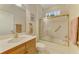 Bright bathroom with a shower-tub combination, glass enclosure, and a white vanity at 1018 Yosemite Dr, Englewood, FL 34223
